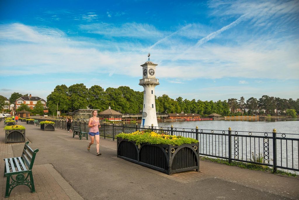 Roath park dam with lighthouse and runner